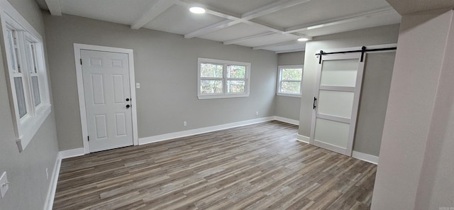 foyer featuring beamed ceiling, a barn door, hardwood / wood-style flooring, and coffered ceiling