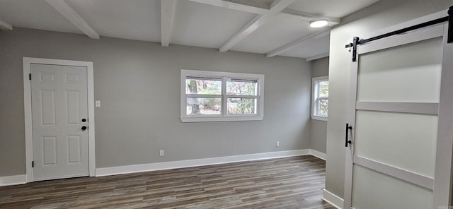 foyer featuring a barn door, beamed ceiling, and hardwood / wood-style flooring