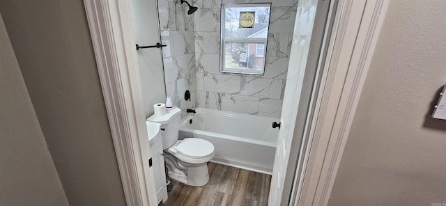 bathroom featuring hardwood / wood-style flooring, tiled shower / bath combo, and toilet