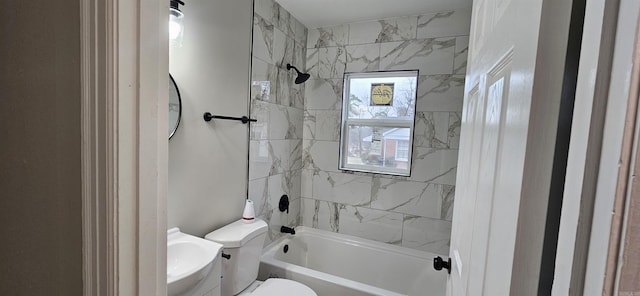 bathroom with tiled shower / bath combo and toilet