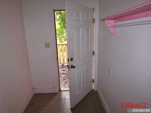 doorway featuring dark tile patterned flooring