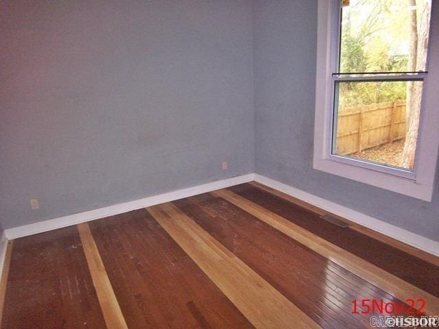 empty room with hardwood / wood-style flooring and a wealth of natural light