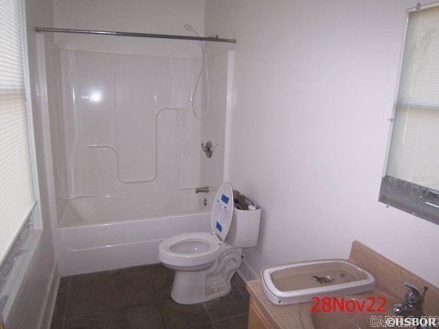 bathroom with tile patterned flooring,  shower combination, and toilet