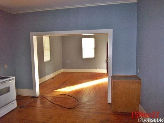 empty room with crown molding and wood-type flooring