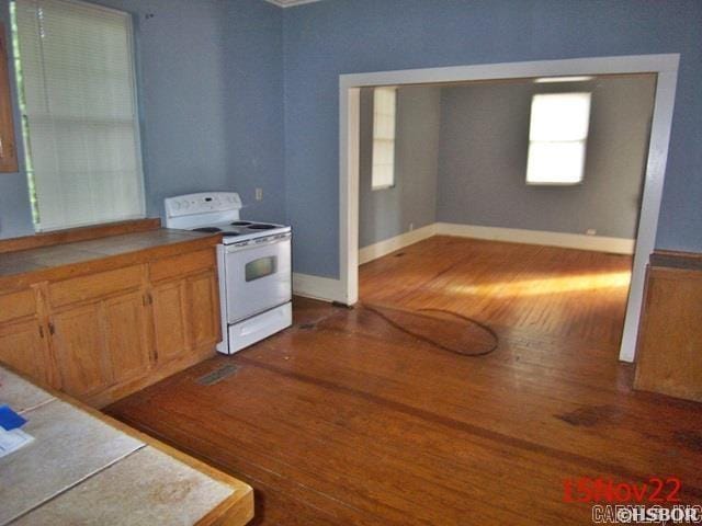 kitchen featuring dark hardwood / wood-style floors, white range with electric stovetop, and tile counters