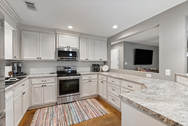 kitchen featuring stainless steel appliances, light stone counters, backsplash, kitchen peninsula, and white cabinets