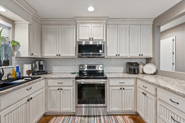 kitchen with tasteful backsplash, light stone countertops, sink, and appliances with stainless steel finishes