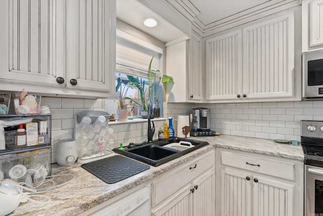 kitchen with light stone counters, sink, appliances with stainless steel finishes, and tasteful backsplash