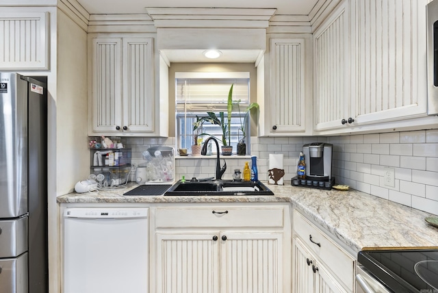 kitchen featuring tasteful backsplash, stainless steel refrigerator, sink, and white dishwasher