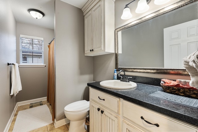 bathroom with tile patterned flooring, vanity, and toilet