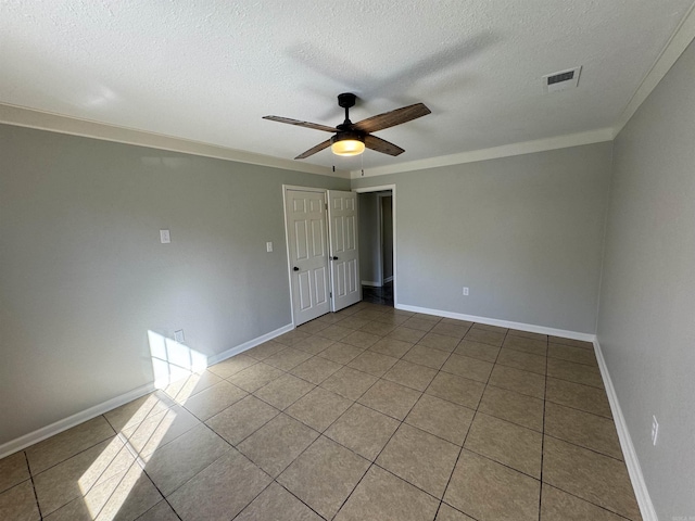 empty room featuring crown molding, light tile patterned floors, a textured ceiling, and ceiling fan