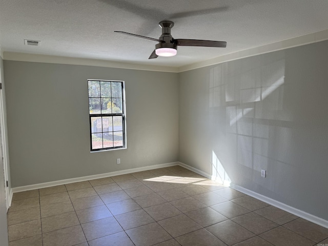 tiled empty room with a textured ceiling, ceiling fan, and ornamental molding