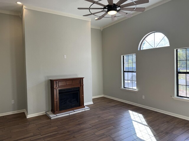 unfurnished living room featuring crown molding, a wealth of natural light, and dark wood-type flooring