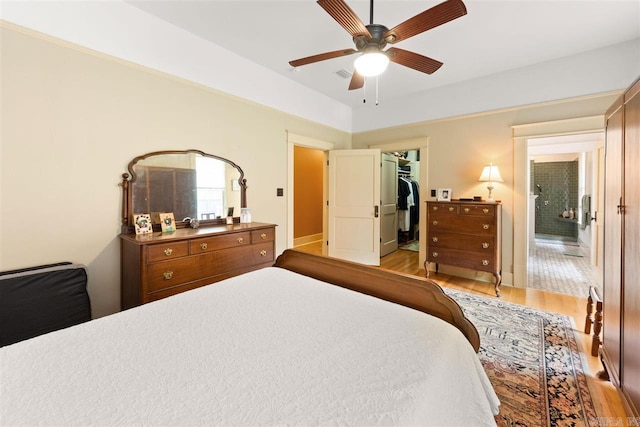 bedroom featuring a closet, a spacious closet, ceiling fan, and light hardwood / wood-style floors