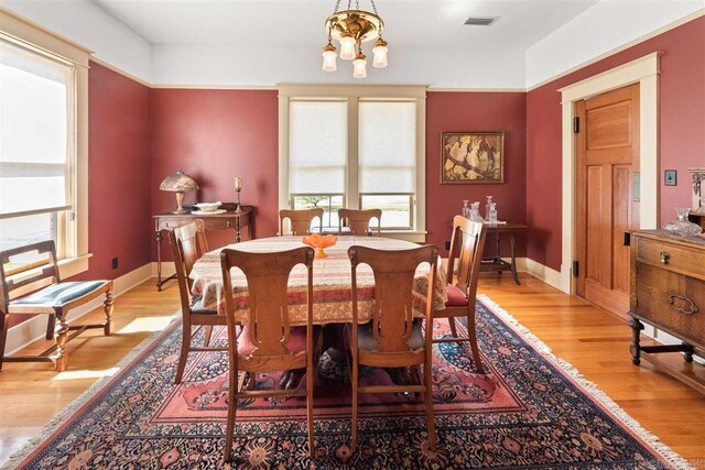 dining area featuring light hardwood / wood-style floors and an inviting chandelier