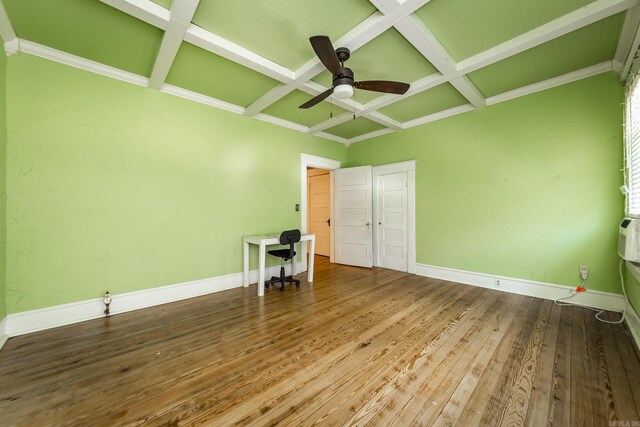 spare room with wood-type flooring, ceiling fan, coffered ceiling, and beam ceiling