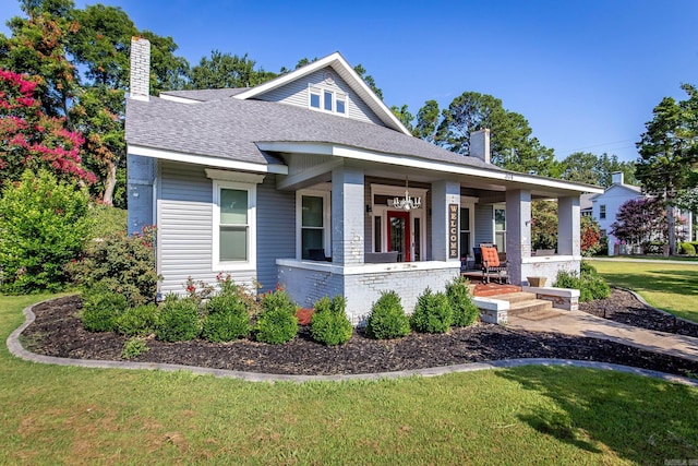 view of front of house featuring covered porch and a front lawn