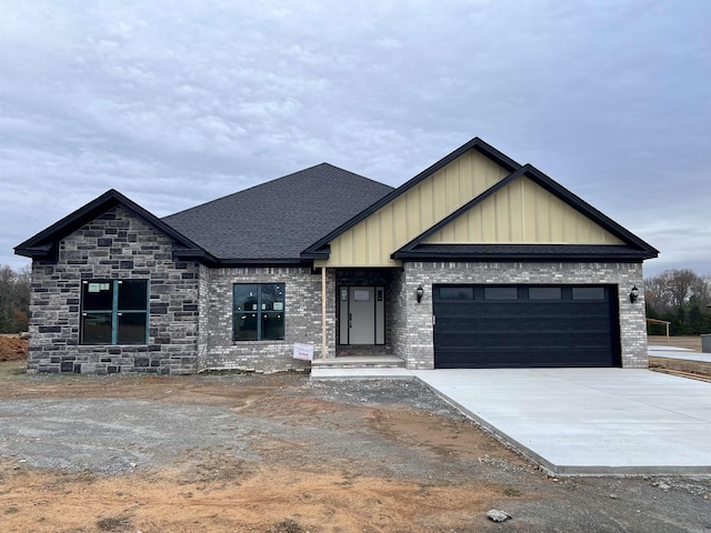 view of front of house featuring brick siding, roof with shingles, an attached garage, board and batten siding, and driveway