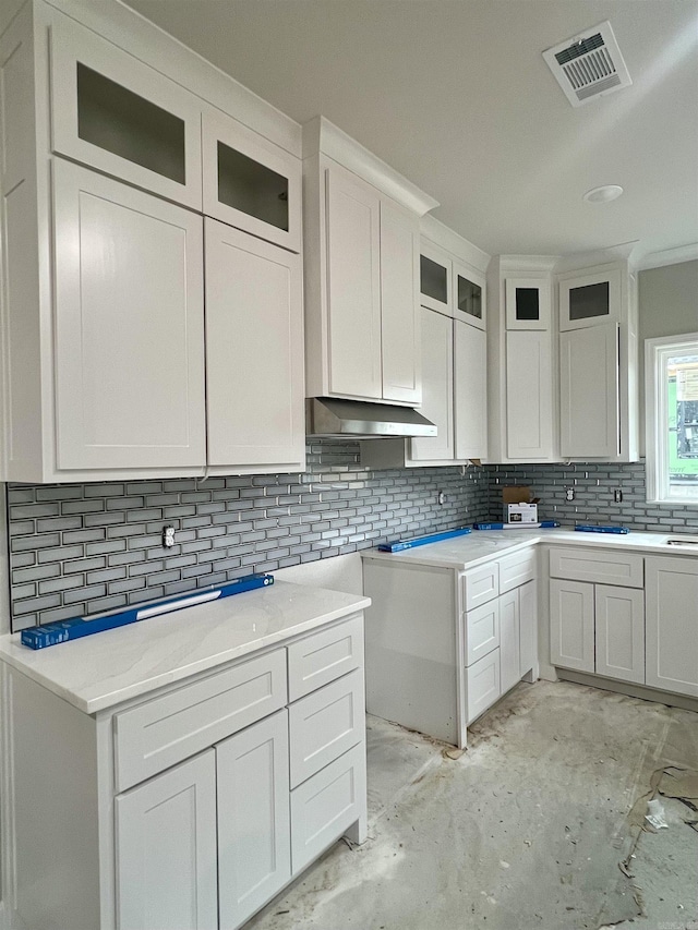 kitchen featuring white cabinets, backsplash, and range hood