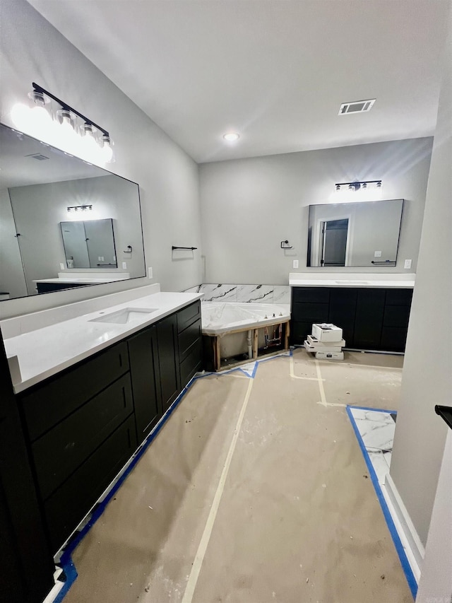 bathroom featuring a bathing tub, vanity, and concrete floors