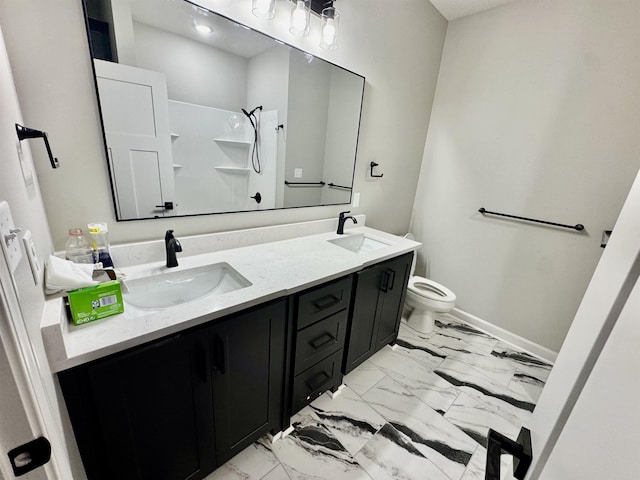 bathroom with marble finish floor, a sink, toilet, and double vanity