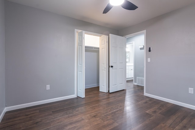 unfurnished bedroom featuring dark hardwood / wood-style flooring, ceiling fan, and a closet