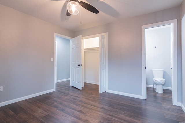 unfurnished bedroom with ceiling fan, dark hardwood / wood-style flooring, connected bathroom, and a closet