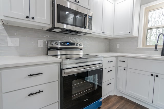 kitchen featuring white cabinetry, sink, tasteful backsplash, dark hardwood / wood-style floors, and appliances with stainless steel finishes