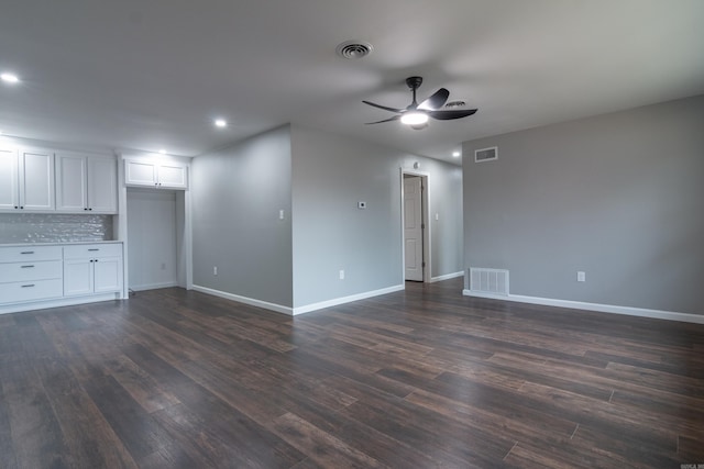 unfurnished living room featuring ceiling fan and dark wood-type flooring