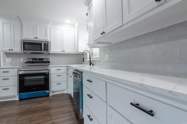 kitchen featuring sink, white cabinetry, backsplash, and appliances with stainless steel finishes