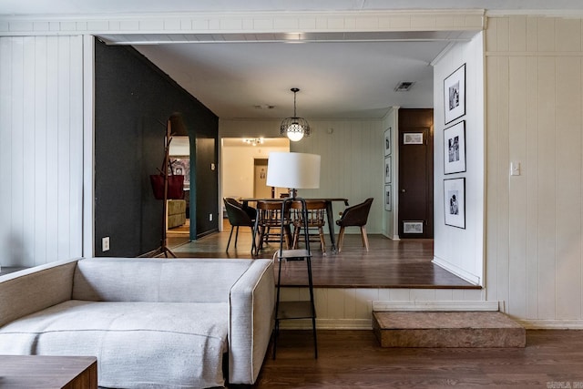 living room featuring wood-type flooring and wooden walls