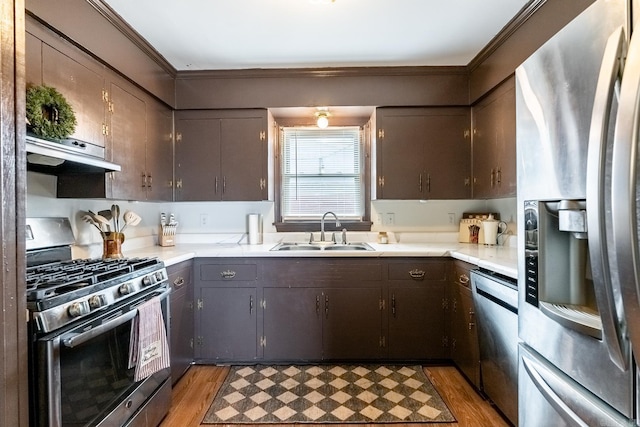 kitchen with sink, stainless steel appliances, light hardwood / wood-style flooring, range hood, and crown molding