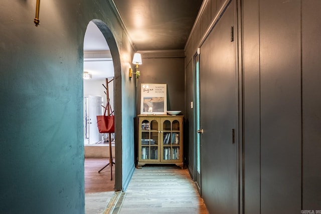 hallway featuring light hardwood / wood-style floors and ornamental molding