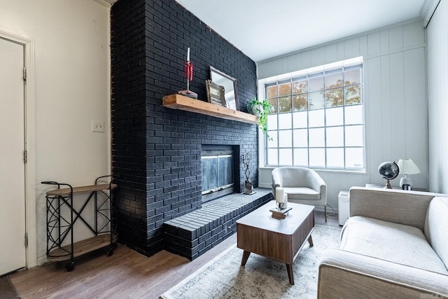 living room featuring light hardwood / wood-style floors and a brick fireplace