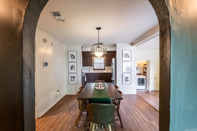 dining area with washer / clothes dryer, hardwood / wood-style flooring, and sink