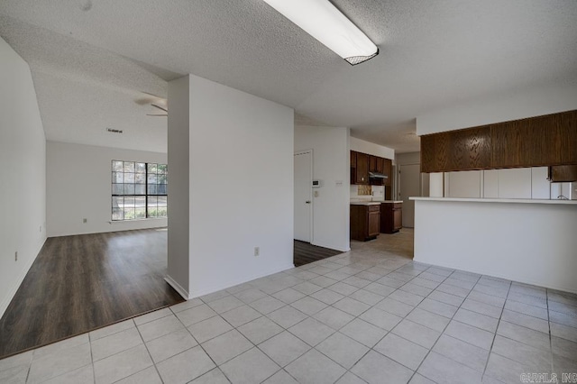 interior space with ceiling fan and a textured ceiling