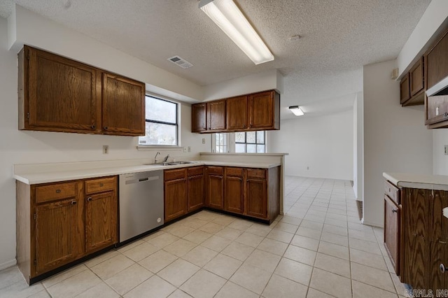 kitchen featuring dishwasher, a textured ceiling, kitchen peninsula, and sink