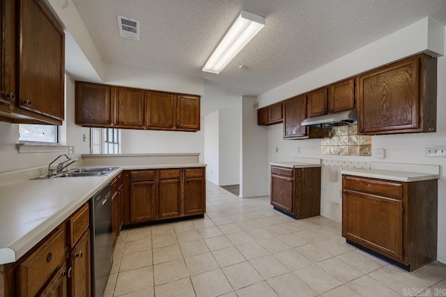 kitchen featuring a textured ceiling, dishwasher, light tile patterned floors, and sink