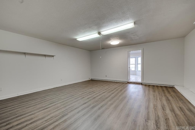 empty room with wood-type flooring and a textured ceiling