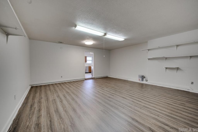 spare room featuring light wood-type flooring and a textured ceiling