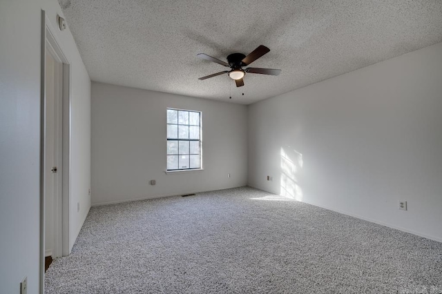 carpeted spare room featuring ceiling fan and a textured ceiling