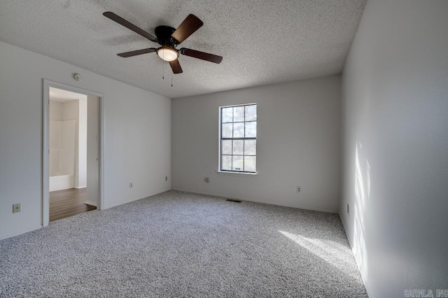 unfurnished room featuring carpet flooring, ceiling fan, and a textured ceiling