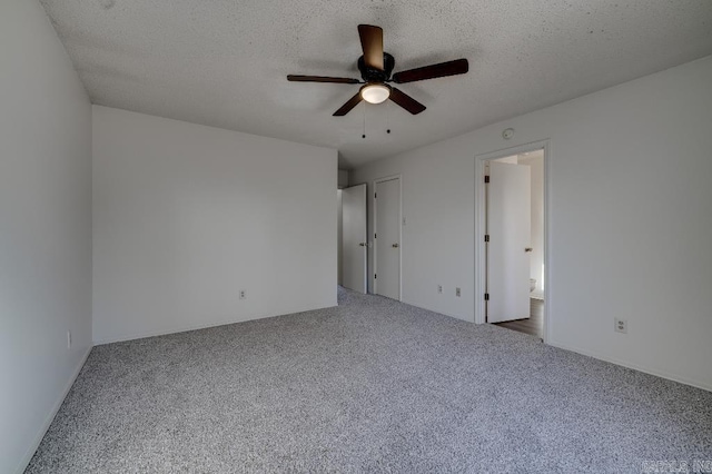 unfurnished bedroom with carpet, a textured ceiling, and ceiling fan