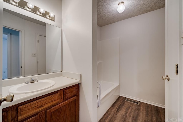 bathroom with vanity, hardwood / wood-style floors, and a textured ceiling