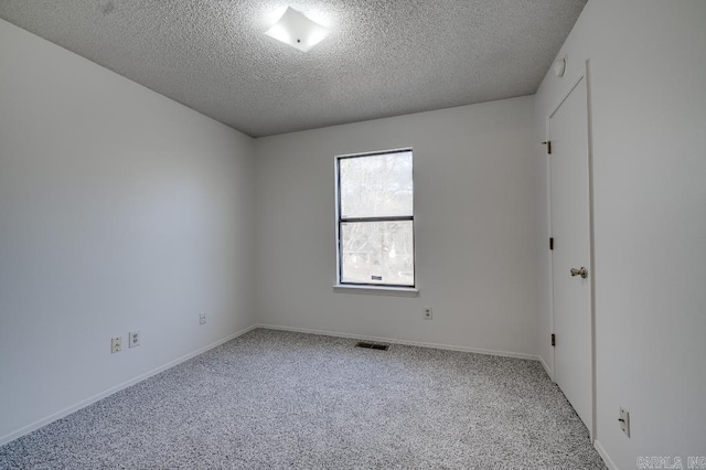 unfurnished room with carpet flooring and a textured ceiling