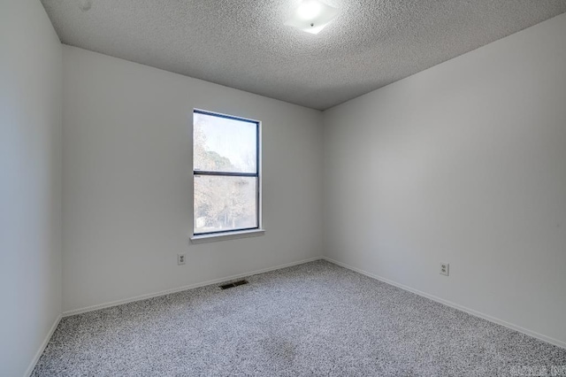 carpeted spare room with a textured ceiling