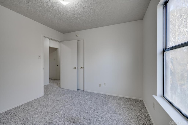 spare room with light colored carpet and a textured ceiling