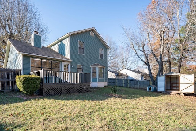 rear view of house with a shed, a deck, and a lawn