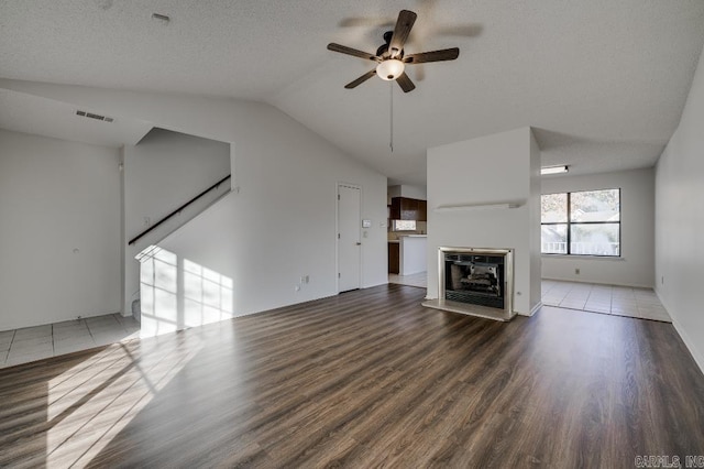 unfurnished living room with a multi sided fireplace, ceiling fan, dark hardwood / wood-style floors, and vaulted ceiling