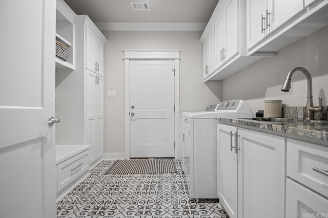 laundry area featuring washer and clothes dryer, cabinets, light tile patterned floors, and sink